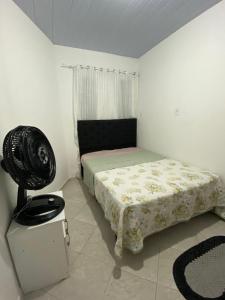 - une chambre avec un lit et un ventilateur dans l'établissement Casa perto da praia em Itapema, à Itapema