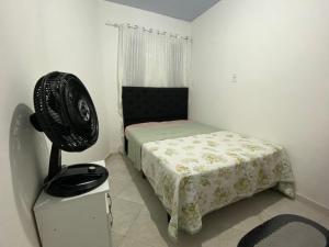 - une chambre avec un lit et un ventilateur dans l'établissement Casa perto da praia em Itapema, à Itapema