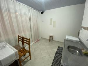 La salle de bains est pourvue d'un lavabo, d'une table et d'une table. dans l'établissement Casa perto da praia em Itapema, à Itapema