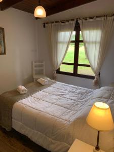 ein Schlafzimmer mit einem großen Bett mit Fenster in der Unterkunft La Casa del Molino in Sierra de la Ventana