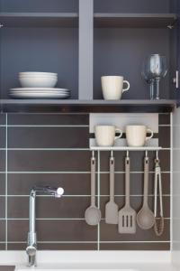a kitchen with utensils on a shelf above a sink at Wecostay Chungmuro in Seoul +89 photos
