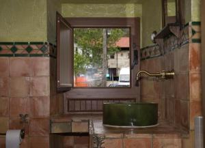 baño con lavabo verde y ventana en Agroturismo Urrutia en Osma