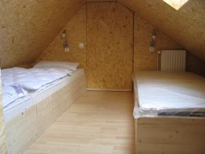 two beds in a attic room with wooden floors at Ferienunterkünfte Boßmann in Steinhude