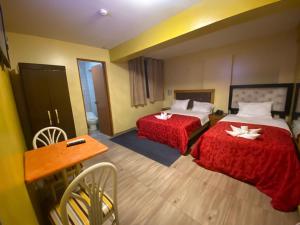 una camera d'albergo con due letti e un tavolo di Hotel SPRING a Lima