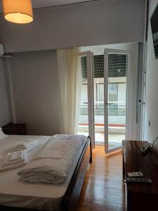 ein Schlafzimmer mit einem Bett und einer Glasschiebetür in der Unterkunft Acropolis view in Lycabettus in Athen + 23 Fotos