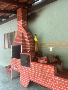 Una chimenea de ladrillo con un televisor encima. en RECANTO DO SABIÁ, en Carolina