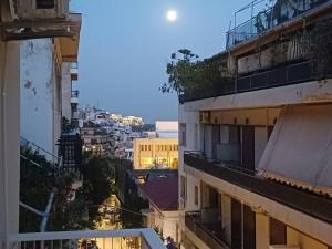 einen Blick auf die Stadt in der Nacht vom Balkon aus in der Unterkunft Acropolis view in Lycabettus in Athen