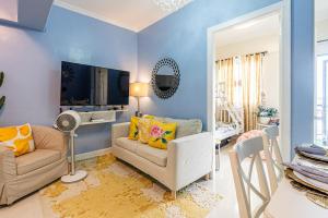 a living room with a couch and a tv at Stylish Mactan Stay Near Airport 2-6 guest in Sudtungan