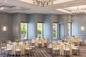 a ballroom with tables and chairs in a room with windows at Portland Sheraton at Sable Oaks in South Portland +37 photos