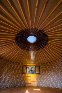 Zimmer mit einer großen Holzdecke und einem Fenster in der Unterkunft Traslasierra Nono Balneario paso de las tropas in Las Calles