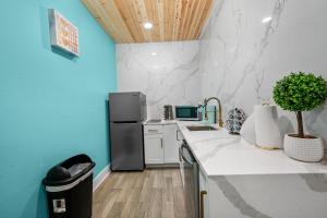 ヒューストンにあるModern Studio Retreat with King Bed, Full Kitchen & Free Parkのキッチン(白いカウンタートップ、黒い冷蔵庫付)