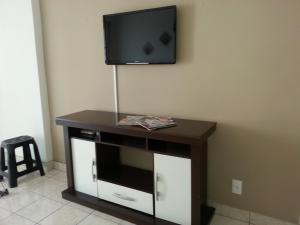 a flat screen tv on top of a tv stand at Apartament Rio Center in Niterói