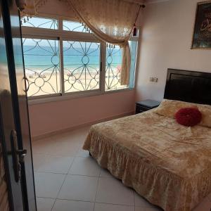 丹吉尔Appartamiento corniche的一间带床的卧室，可欣赏海滩美景