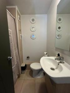 a white bathroom with a toilet and a sink at Departamento equipado 201 Ovalle in Ovalle