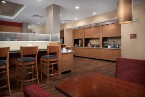 a kitchen with wooden cabinets and a bar with stools at TownePlace Suites Fort Worth Northwest Lake Worth in Fort Worth