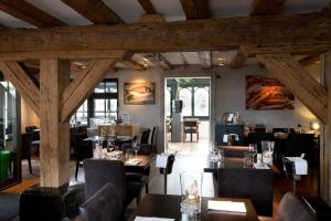 a restaurant with wooden ceilings and tables and chairs at Texel Suites in Oudeschild