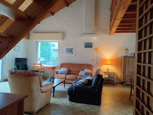 Una sala de estar con dos sofás y una mesa. en Maison familiale près plage St Brevin, animaux admis, parking privé - FR-1-364-40, en Saint-Brevin-les-Pins