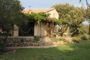 a small white house with a stone wall at Côté Chênes Verts - Chambres d'hôtes in Viols en Laval