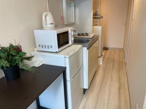 a kitchen with a microwave on top of a refrigerator at Apartment Shinjuku 201 in Tokyo