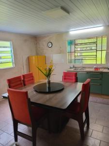 una cucina con un tavolo di legno e sedie rosse di Sitio dos pinhais a Pelotas
