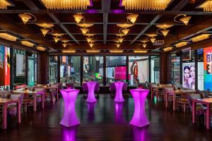 um restaurante com cadeiras e mesas cor-de-rosa num quarto em Renaissance New York Times Square by Marriott em Nova Iorque
