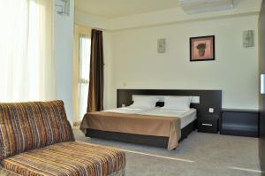 a hotel room with a bed and a couch at Vikeya Guest House in Sapareva Banya +79 photos