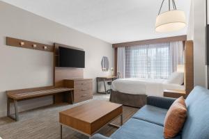 ein Hotelzimmer mit einem Bett und einer Couch in der Unterkunft Holiday Inn Express Hotel & Suites Coralville by IHG in Coralville
