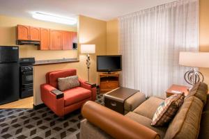a living room with a couch a chair and a kitchen at Ville 7877 in Centennial