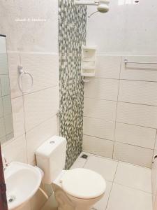a bathroom with a white toilet and a sink at Chalé Di vino in Porto Seguro