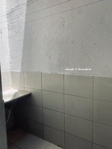 a bathroom with a sink and a tiled wall at Chalé Di vino in Porto Seguro