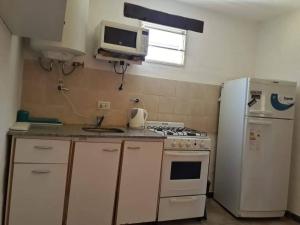 a kitchen with a white stove and a refrigerator at Cabañas Cuñas del Trapiche in Trapiche