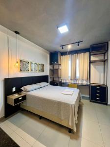 a bedroom with a large bed and blue cabinets at Studio Estilo Industrial 03 in Mossoró