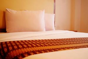 Ένα ή περισσότερα κρεβάτια σε δωμάτιο στο Sultan Hotel Banda Aceh