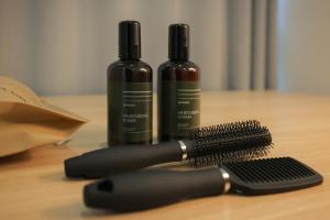 two hair brushes and a bottle of wine on a table at Aank Hotel Sejong in Sejong +54 photos