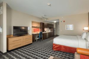 a hotel room with a bed and a flat screen tv at TownePlace Suites by Marriott Owensboro in Owensboro