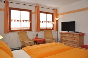 una camera con letto e TV a schermo piatto di Steakhouse & Pension Crazy Horse a Suhl