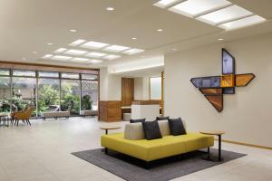 a living room with a yellow couch in a lobby at Four Points Flex by Sheraton Kyoto Oike in Kyoto