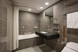 a bathroom with a sink and a bath tub at Four Points Flex by Sheraton Kyoto Oike in Kyoto