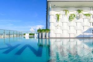 カントーにあるWink Hotel Can Tho Ninh Kieu Wharf - 24hrs Stay & Rooftop Pool Barのスイミングプール付きの建物の表示