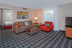 ノックスビルにあるTownePlace Suites Knoxville Cedar Bluffのリビングルーム(ソファ、椅子、テレビ付)