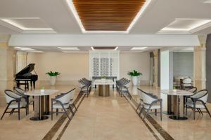 a room with tables and chairs and a piano at Danang Marriott Resort & Spa in Danang
