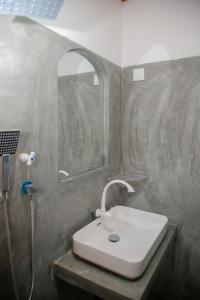a bathroom with a white sink and a shower at Hill Top Heaven in Hikkaduwa +39 photos