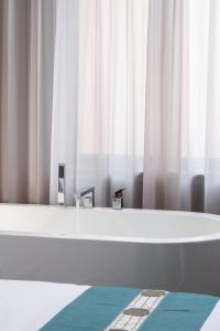 北京East Sacred Hotel--Very near Beijing Tiananmen Square ,the Forbidden City,The temple of heaven ,3 minutes' walk to Wangfujing subway ,Located in the center of Beijing, many shopping malls around,Free laundry service,Newly renovated hotel的配有白色窗帘的客房内的浴缸
