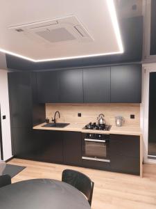 a kitchen with a sink and a stove at Haus Boat LIBERTY in Murowaniec