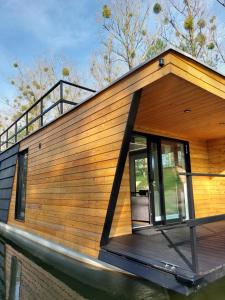 a house on the water with a large window at Haus Boat LIBERTY in Murowaniec