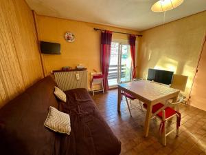 un soggiorno con un divano e un tavolo di T2 fonctionnel Les Angles - 4 pers, Parking, Ski proche - FR-1-758-36 a Les Angles