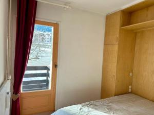 una camera da letto con finestra, letto e porta di T2 fonctionnel Les Angles - 4 pers, Parking, Ski proche - FR-1-758-36 a Les Angles