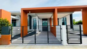 a building with orange columns and a gate at Vela House Songkhla in Songkhla