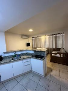 a kitchen with a sink and a counter top at Suites Centro Torres in Torres