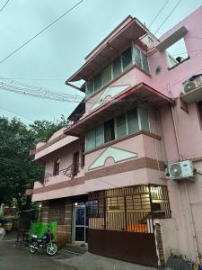 a pink building with a motorcycle parked in front of it at Villa De Pondicherry in Puducherry